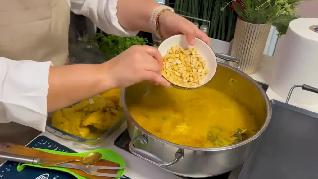 Lentils and fenugreek seeds being added to chicken and onions for Moroccan Rfissa